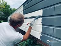 schilder schildert de bungalow van licht naar een antracieten kleur.