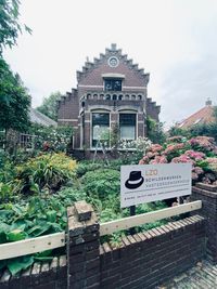 Voorzijde woning met reclamebord.